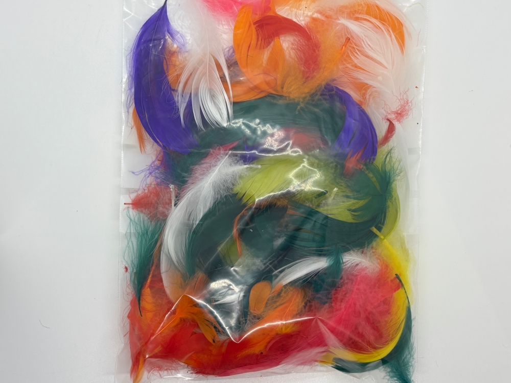 En stor pose 23 x 16 cm med fjær av forskjellige farger som brukes over fellene for at dyret lettere skal bli oppmerksom på at her er det noe av interesse.